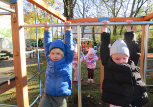 Dziewczynki na drabinkach na placu zabaw.