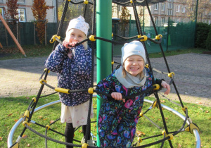 Dziewczynki pozują do zdjęcia na placu zabaw.