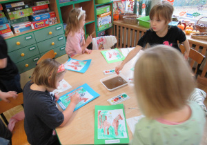 Dziewczynki malują farbami.