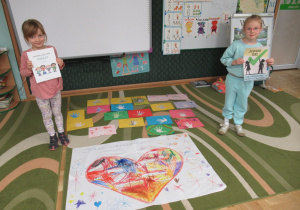 Dziewczynki prezentują prace wykonane podczas zajęć.