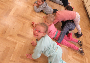 Dzieci tworzą tunel, jedna dziewczynka przechodzi przez niego.