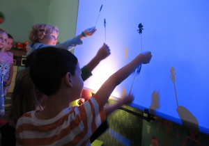 Dzieci bawią się w teatr cieni.