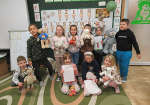 Dzieci pozują do zdjęcia ze swoimi pluszowymi misiami.