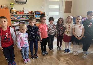 Dzieci stoją na baczność podczas śpiewania hymnu.