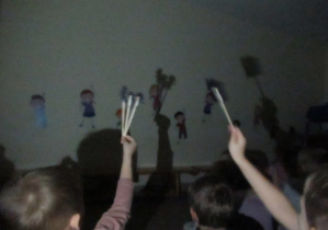 Dzieci bawią się w teatr cieni.