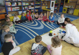 Dzieci siedzą na dywanie podczas warsztatów Labo.