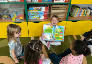 Dziewczynka pokazuję książkę swoim koleżankom