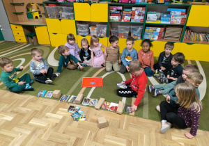 Chłopiec układa rytm z paczek i kartek pocztowych