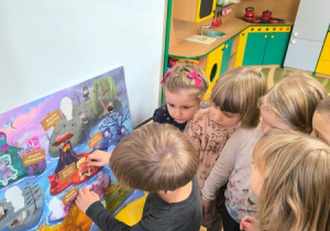 Chłopiec przykleja na plakat naklejkę przedtawiającą postać Gniewka