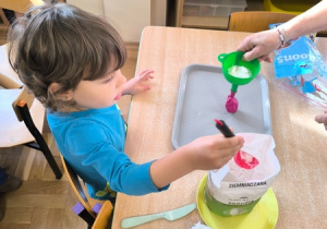 Chłopiec wsypuje mąkę do balona