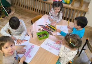 Dzieci kolorują obrazek przedstawiający kredkę