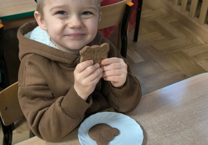 Chłopiec je ciastko w kształcie misia