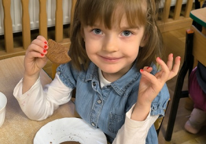 Dziewczynka je ciastko w kształcie misia