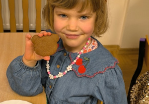 Dziewczynka je ciastko w kształcie misia