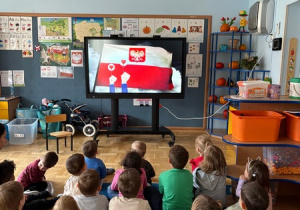 Dzieci ogladają film edukacyjny na temat symboli narodowych