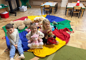 Dzieci siedzą na chuście animacyjnej