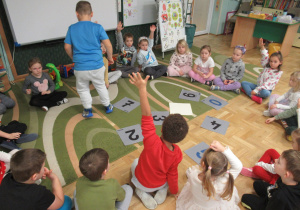 Dzieci siedzą w kole podczas zajęć.