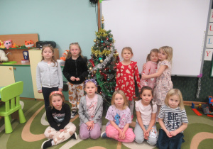 Dziewczynki pozują do zdjęcia przy choince.