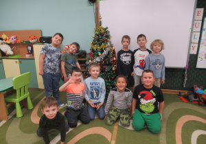 Chłopcy pozują do zdjęcia przy choince.