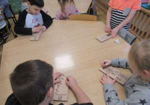 Dzieci rysują węglem.