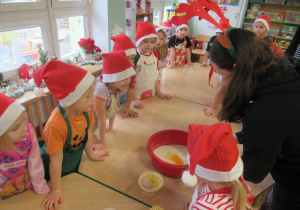 Dzieci stoją wokół stołu, na stole produkty do ciasta na pierniczki.