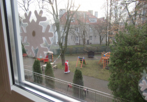 Święty Mikołaj spaceruje po ogródku przedszkolnym.