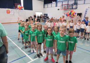 Dzieci stoją w sali gimnastycznej podczas Przedszkolimpiady.