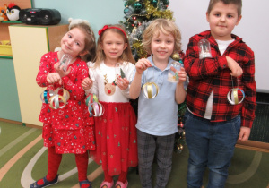 Dzieci pozują do zdjęcia z pracami wykonanymi podczas warsztatów.