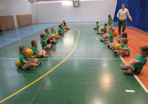 Dzieci ćwiczą na zajęciach z koszykówki.