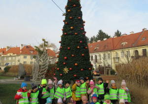 Dzieci pozują do zdjęcia przy choince.