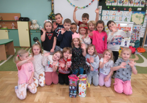 Świętujemy urodziny dziewczynki, dzieci stoja wokół dziewczynki, która ma na głowie koronę.