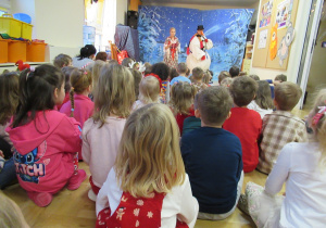 Dzieci siedzą na podłodze, przed nimi Góralka i Bałwanek.