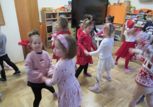 Dzieci tańczą w parach podczas spokania z Mikołajem.
