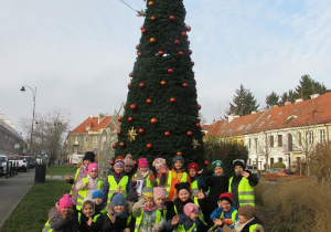 Dzieci pozują do zdjęcia przy choince.