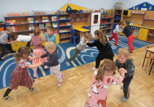 Dzieci w parach trzymają się za ręce, biorą udział w zabawie ruchowej "siłowance".