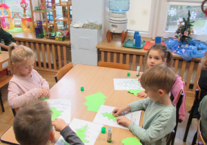 Dzieci wykonują prace plastyczne - choinki.