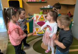 Dzieci trzymają plakat przedstawiajacy trójkąty