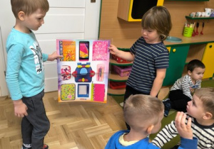 Dzieci trzymają plakat przedstawiajacy prostokąty