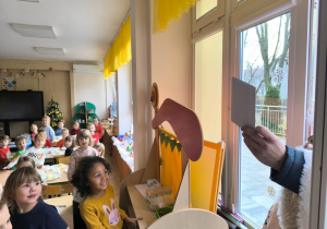 Święty Mikołaj wręcza dzieciom list przez okno