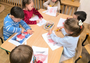 Dzieci wycinają postać Świętego Mikołaja