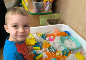 Chłopiec bawi się piaskiem kinetycznym