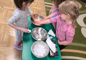 Dzieci zanurzają dłonie w misce wypełnionej wodą