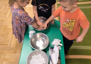 Dzieci zanurzają dłonie w misce wypełnionej wodą