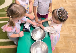 Dzieci dotykają kostek lodu