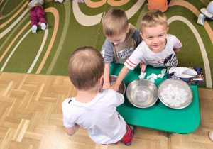 Dzieci zanurzają dłonie w misce wypełnionej wodą