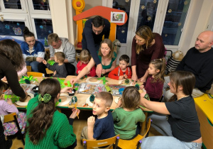 Dzieci wykonują z rodzicami ozdoby świąteczne