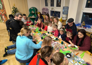 Dzieci wykonują z rodzicami ozdoby świąteczne