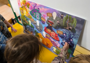 Dziewczynka przykleja naklejkę na plakat