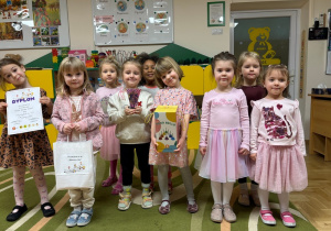 Dziewczynki stoją i trzymają nagrody za udział w konkursie muzycznym