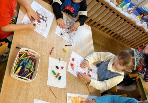 Dzieci wyklejają plasteliną wybrane elementy kolorowanki